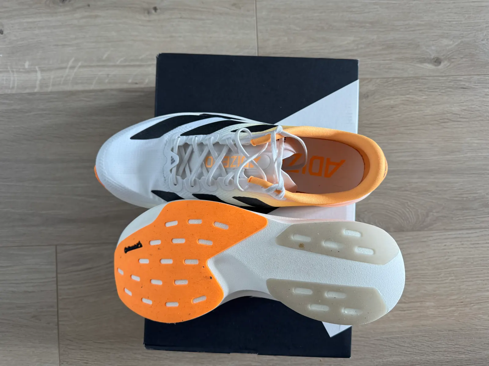 Outsole of the Adidas Adizero EVO SL Woven with orange Continental forefoot rubber and translucent heel pads